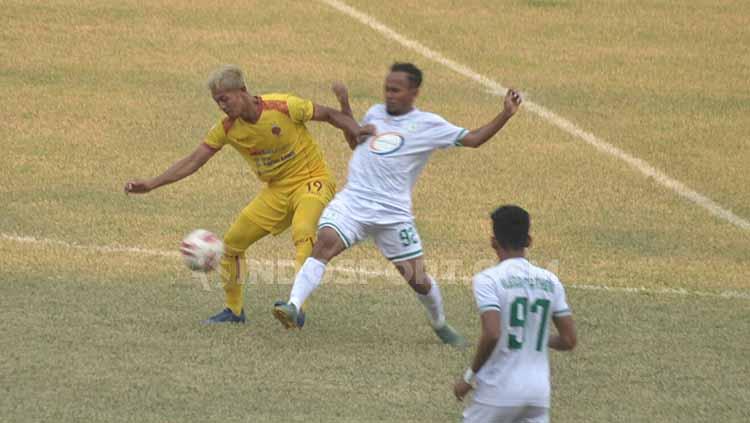 Yongki Aribowo berusaha melindungi bola dari pemain Blitar Bandung United.