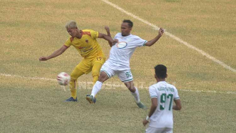 Yongki Aribowo berusaha melindungi bola dari pemain Blitar Bandung United. - INDOSPORT