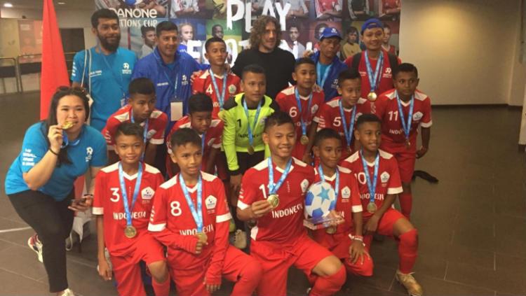 Tim Indonesia 2019 berfoto bersama Brand Ambassador Danone Nations Cup sekaligus pesepakbola senior, Carles Puyol. - INDOSPORT