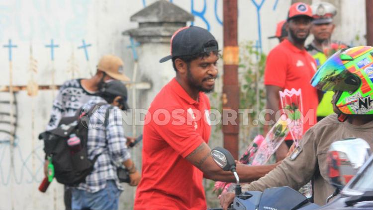 Gelandang andalan Persipura, Imanuel Wanggai saat membagikan bunga kepada warga pengguna jalan.