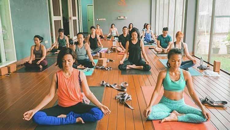 Wanda Hamidah (kaos oren) melakukan gerakan yoga untuk pemula diawali dengan duduk dengan gaya bersila dengan meletakkan kedua tangan tepat diatas lutut.