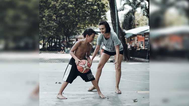 Wanda Hamidah tengah bermain bola basket bersama putranya.