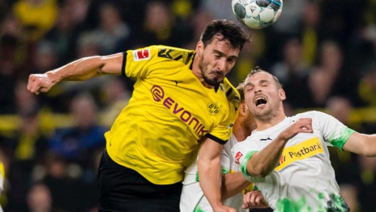 Mats Hummels saat duel udara dalam pertandingan Bundesliga antara Borussia Dortmund vs Borussia Monchengladbach, Minggu (20/10/19) dini hari WIB. Copyright: twitter.com/BVB
