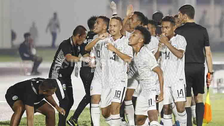 Aksi provokatif kapten Timnas Timor Leste U-19, Gumario da Silva dan beberapa rekannya ke arah suporter Indonesia usai Timor Leste meyamakan kedudukan 1-1. Copyright: Herry Ibrahim/INDOSPORT