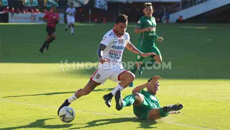 Winger Bali United, Stefano Lilipaly berusaha menghindari tackle dari bek PSS Sleman, Asyraq Gufron Ramadhan dalam laga pekan ke-27 Shopee Liga 1 2019 di Stadion Maguwoharjo Sleman, Rabu (06/11/19) sore.