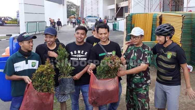 Azrul Ananda berfoto dengan Bonek yang membagikan bunga saat acara kerja bakti Stadion GBT, Jumat (11/11/19).