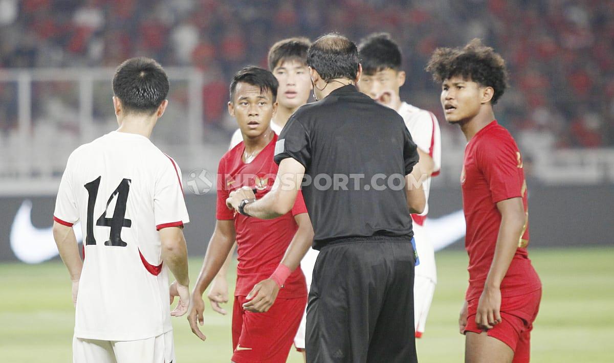 Wasit mencoba memberi instruksi ke pemain Timnas Indonesia U-19 dan Korea Utara dalam Kualifikasi Piala Asia U-19 2020.
