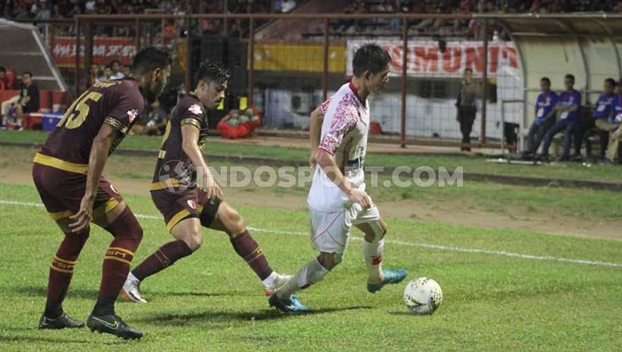 Pemain klub Liga 1 PSM Makassar, Benny Wahyudi dan Hasim Kipuw (merah) membayangi gelandang Persipura Jayapura, Oh InKyun (putih).