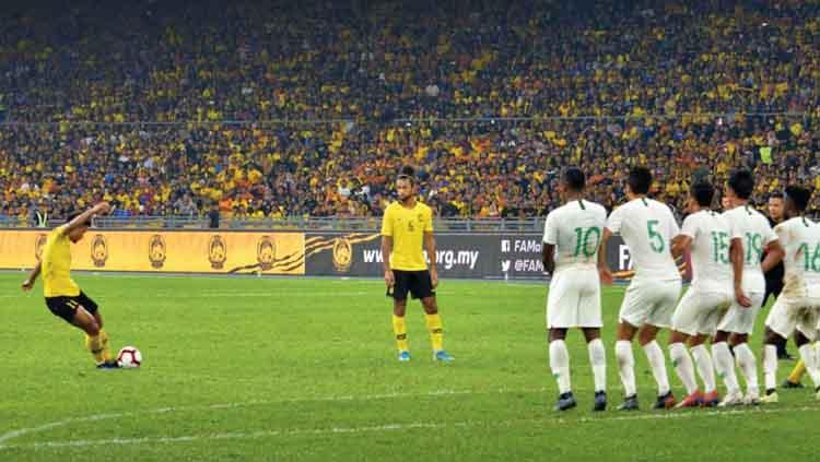 Salah satu pemain Malaysia melakukan tendangan bebas