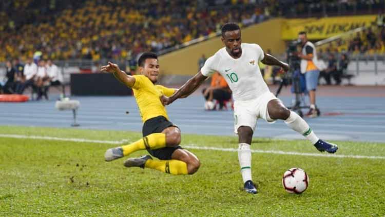 Greg Nwokolo berusaha mengontrol bola dari serangan pemain Malaysia.