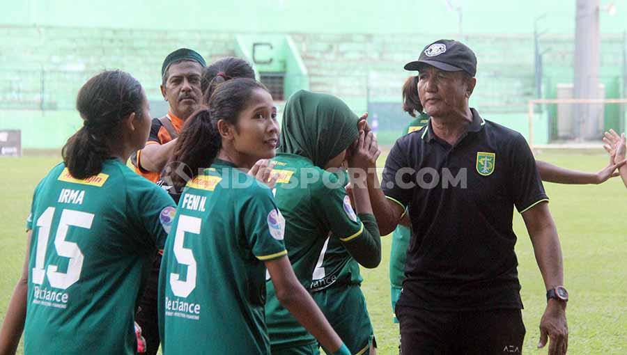 Pelatih Persebaya Putri Ridwan Anwar (bertopi) memberikan selamat ke anak didiknya usai mencetak gol ke gawang Bali United putri, Rabu (20/11/19). - INDOSPORT