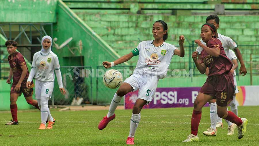 Pemain Persebaya putri Feni Norrahma berusaha menghalangi pemain PSM Makassar Sulfiati, Selasa (19/11/19) dalam laga Liga 1 putri. - INDOSPORT