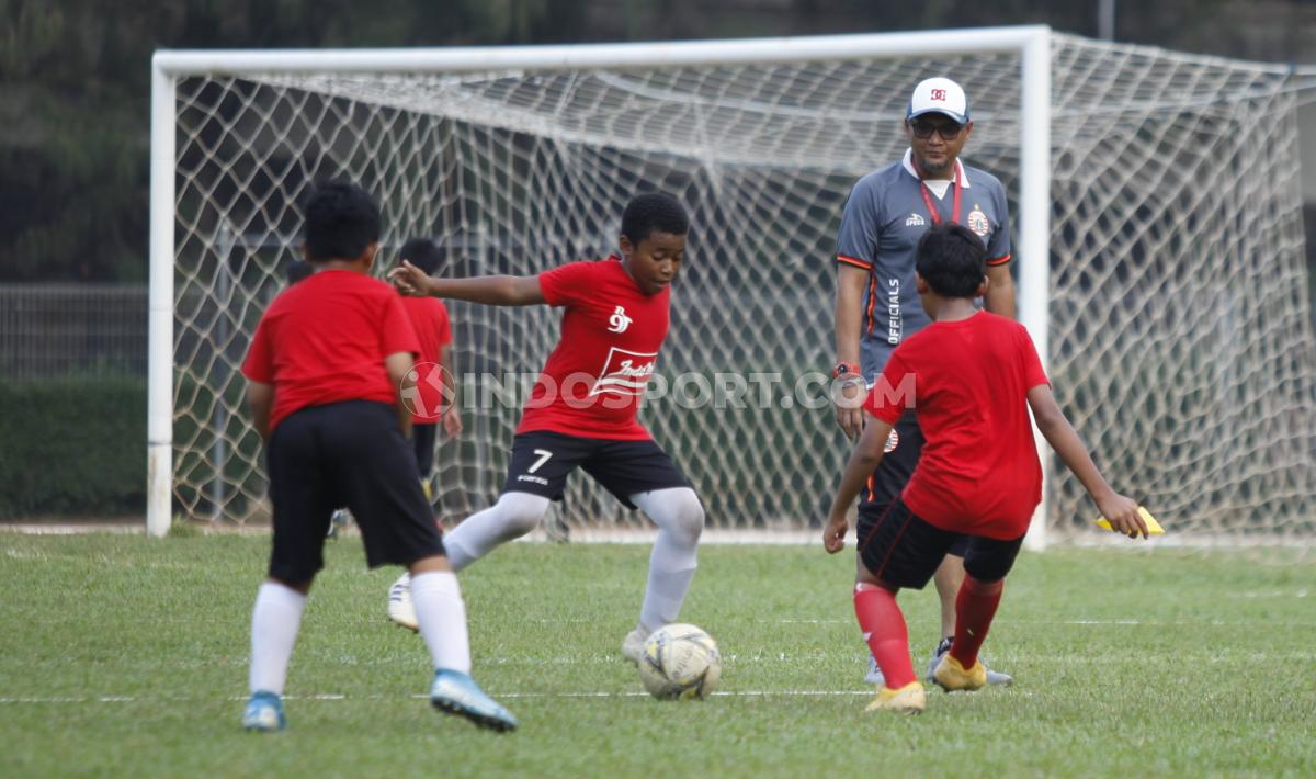 Anak-anak peserta coaching clinic yang digelar Persija unjuk gigi saat bermain sepak bola.