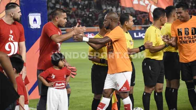 Kapten Persipura Jayapura, Boas Solosa, bersalaman dengan kiper Persija Jakarta, Andritany, sebelum bertanding di Liga 1 2019.