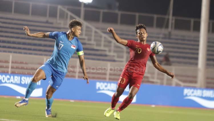 Pemain Timnas Indonesia U-23, Osvaldo Haay (kanan) mencoba menjaga penguasaan bola di tengah penjagaan pemain Singapura dalam lanjutan penyisihan Grup B SEA Games 2019, Kamis (28/11/2019).