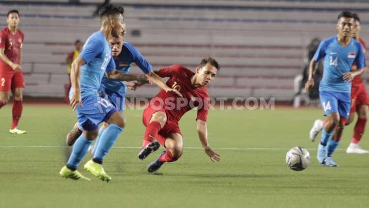 Egy Maulana Vikri (kanan) berjibaku untuk mengejar bola di laga Timnas Indonesia U-23 vs Singapura dalam lanjutan SEA Games 2019, Kamis (28/11/2019).