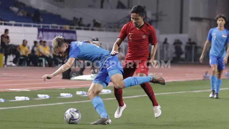 Pemain Timnas Indonesia U-23, Evan Dimas (kanan) melakukan tekanan kepada pemain Singapura untuk merebut bola.