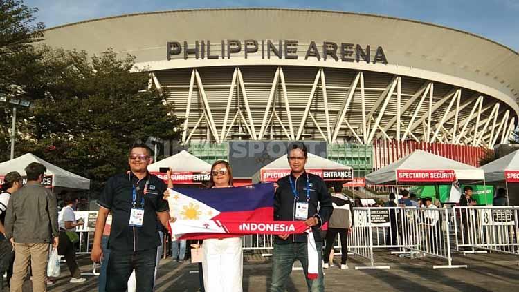 Salah satu warga Filipina membentangkan bendera negaranya di depan Philippine Arena jelang opening SEA Games 2019.