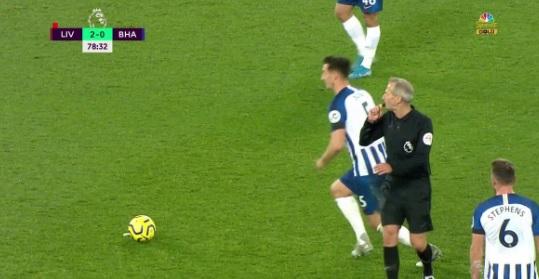 Wasit Martin Atkinson terlihat meniup peluit sambil melihat ke arah kiper Liverpool Adrian saat pemain Brighton mulai menendang. Copyright: https://twitter.com/NBCSportsSoccer