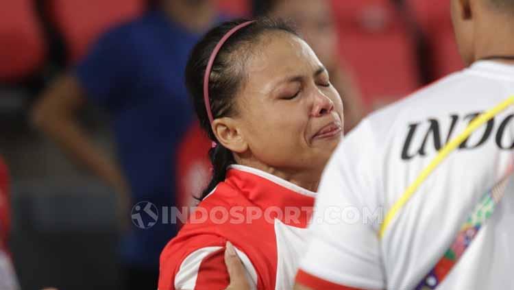 Atlet angkat besi Indonesia, Lisa Setiawati tak kuasa menahan air matanya setelah hanya meraih medali perak SEA Games 2019 di Filipina. - INDOSPORT