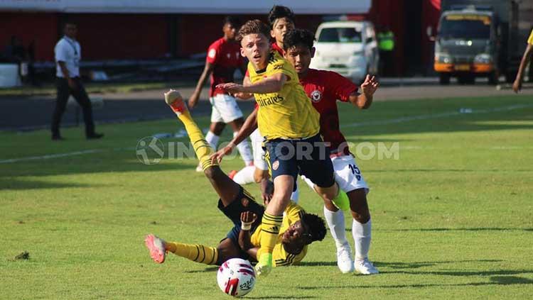 Kapten Arsenal FC U-18, Ben Arron Cottrel saat merebut bola yang dikuasai bek Indonesia U-20 Allstar, Salman Alfarid dalam Bali U-20 International Cup 2019 di Stadion Kapten I Wayan Dipta, Gianyar, Minggu (1/12/19) sore. - INDOSPORT