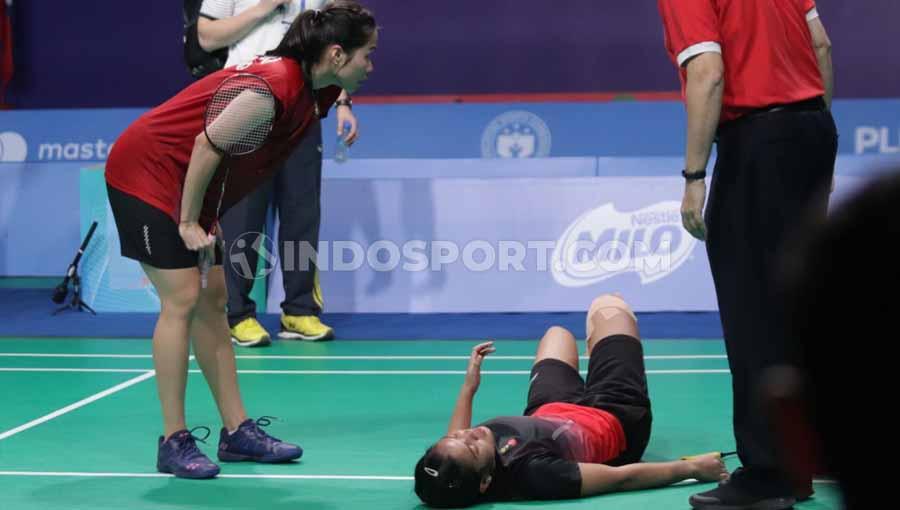 Gregoria Mariska Tunjung terkapar kesakitan pasca terpleset saat hendak menghalau bola dan dihampiri oleh Ratchanok Intanon.
