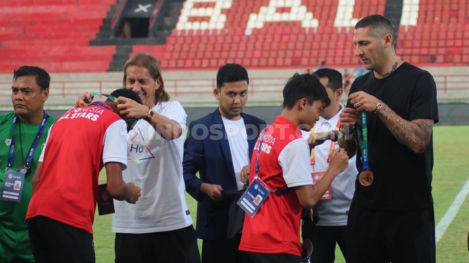 Legenda Real Madrid, Michel Salgado (kiri) dan legenda Inter Milan, Marco Materazzi saat mengalungkan medali juara ketiga kepada tim Indonesia U-20 Allstar. - INDOSPORT