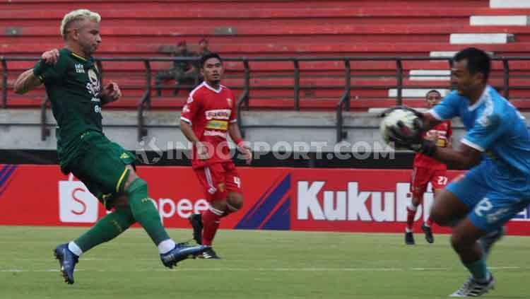 Peluang pemain Persebaya, Diogo Campos (kiri) digagalkan kiper Badak Lampung, Dikri Yusron pada laga Liga 1 di Stadion Gelora Bung Tomo, Sabtu (21/12/19).