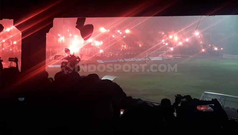Suporter Persela meluapkan kebahagiaan batal degradasi dari Liga 1 2019 ke Liga 2 2020 dengan menyalakan puluhan flare dan kembang api di bawah derasnya hujan, pasca menang 2-0 atas Semen Padang di Stadion Surajaya Lamongan. - INDOSPORT