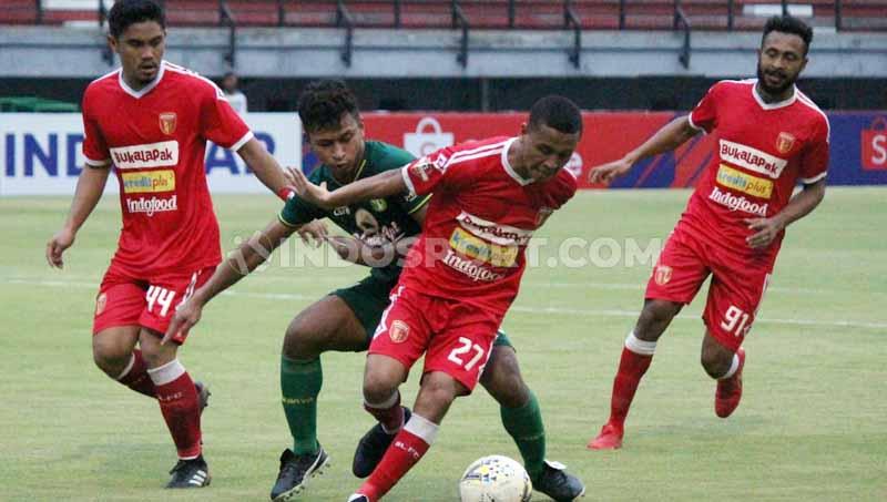 Pemain Persebaya, Osvaldo Haay berebut bola dengan pemain Badak Lampung, Aulia Hidayat (tengah) pada laga Liga 1 di Stadion Gelora Bung Tomo, Sabtu (21/12/19).