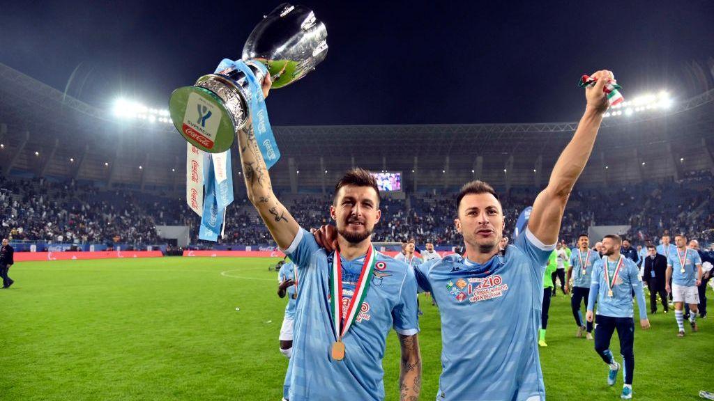 Francesco Acerbi dan Stefan Radu mengangkat trofi Piala Super Italia