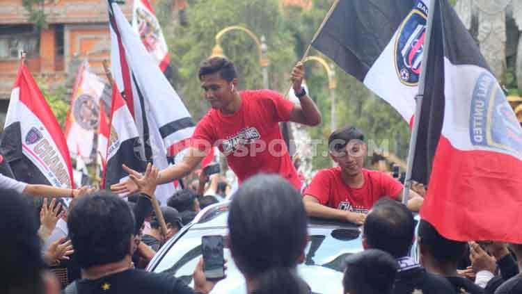 Ahmad agung dan Hanis Saghara berinteraksi dengan para suporter Bali United saat sesi konvoi perayaan juara Liga 1 2019.