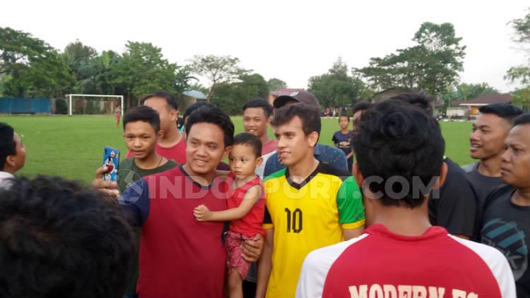 Egy Maulana Vikri saat meladeni foto bersama warga sekitar di lapangan bola Sri Semayang, Sunggal, Deli Serdang, Sumatera Utara, Rabu (25/12/19) petang. Aldi Aulia Anwar/INDOSPORT