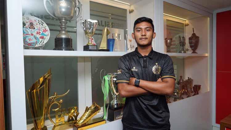 Muhammad Rafli Mursalim berfoto di lemari trofi Persija Jakarta usai resmi bergabung ke klub berjuluk Macan Kemayoran tersebut. Copyright: Media Persija