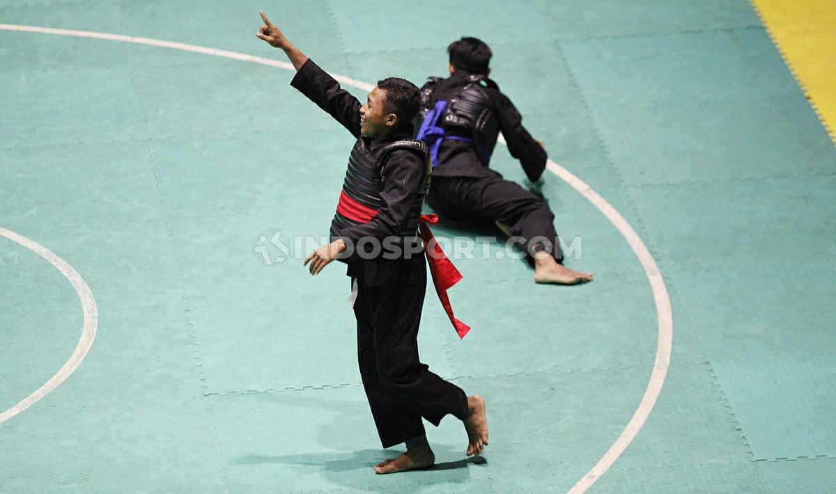 Selebrasi pesilat Lampung, Hafid Alfaqih (kiri) saat mendapatkan poin atas lawannya Pesilat Jawa Tengah, Haris Abdiyanto pada laga nomer Dewasa B Putra Kejurnas dan Festival III Pagar Nusa di Padepokan Silat TMII, Jakarta, Minggu (05/01/20).