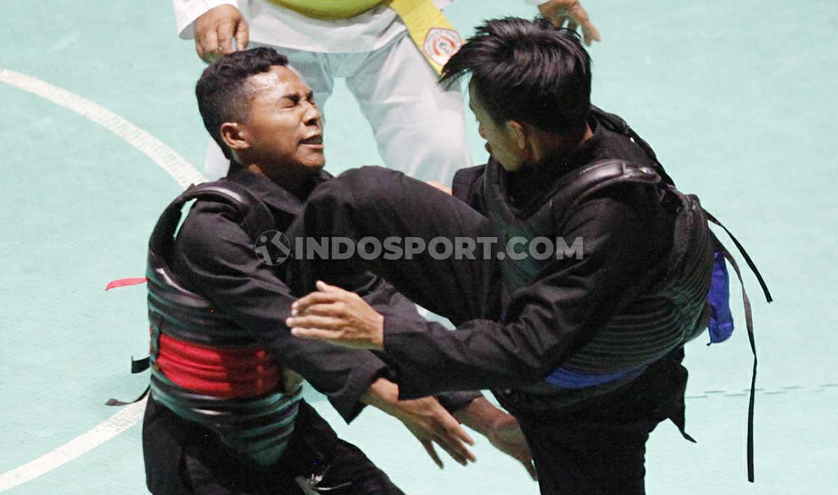 Pesilat Jawa Tengah, Haris Abdiyanto (kanan) melayangkan tendangan keras ke arah lawannya Pesilat Lampung, Hafid Alfaqih pada laga nomer Dewasa B Putra Kejurnas dan Festival III Pagar Nusa di Padepokan Silat TMII, Jakarta, Minggu (05/01/20).