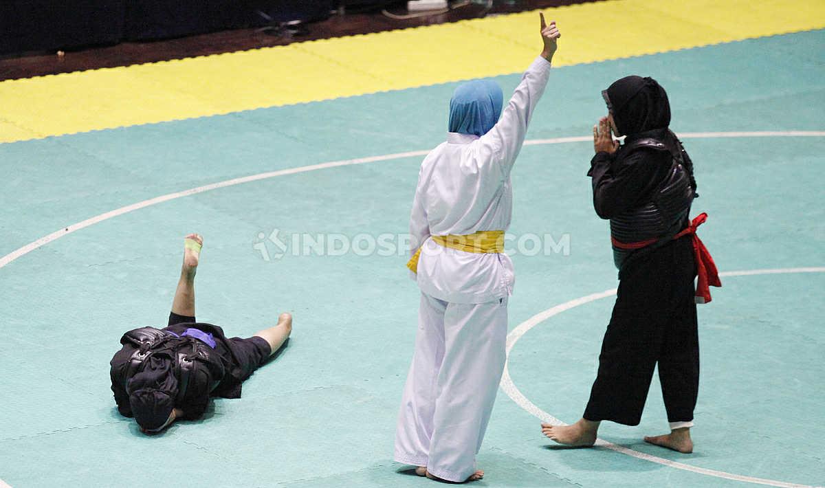 Pesilat putri (kanan) mendapat peringatan wasit usai melakukan pukulan terlarang kepada lawannya pada laga nomer Dewasa B Putri Kejurnas dan Festival III Pagar Nusa di Padepokan Silat TMII, Jakarta, Minggu (05/01/20).