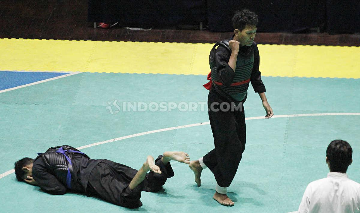 Pesilat Pusdiklat DIY, Ahmad Fauzan (kanan) berhasil menjatuhkan lawannya pesilat Gorontalo, Djuna Dwimas pada laga nomer Dewasa B Putra Kejurnas dan Festival III Pagar Nusa di Padepokan Silat TMII, Jakarta, Minggu (05/01/20).