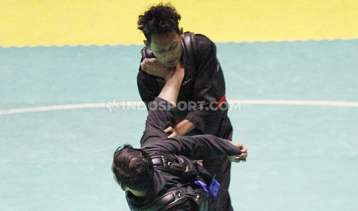 Pesilat Pusdiklat DIY, Ahmad Fauzan (atas) mendapat tendangan telak dari lawannya pesilat Gorontalo, Djuna Dwimas pada laga nomer Dewasa B Putra Kejurnas dan Festival III Pagar Nusa di Padepokan Silat TMII, Jakarta, Minggu (05/01/20).