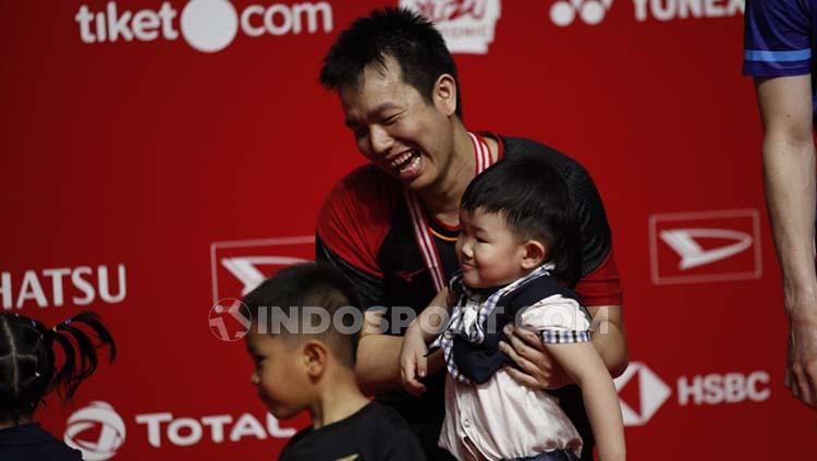 Hendra Setiawan tak berhenti tertawa saat berusaha menggendong anak ketiganya, Russel di podium juara kedua Indonesia Masters 2020.
