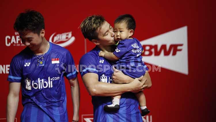 Pasangan Kevin Sanjaya di nomor ganda putra, Marcus Gideon tampak menciumi anaknya di podium juara Indonesia Masters 2020.
