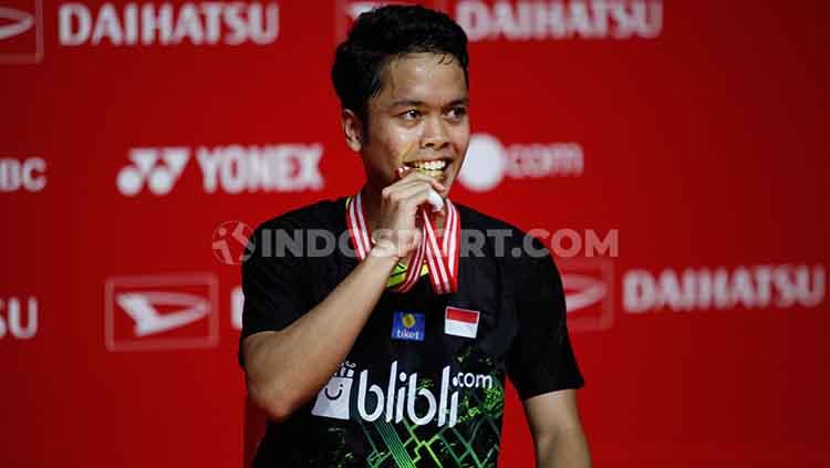 Kebahagiaan Anthony Ginting menggigit medali kemenangannya setelah menang atas Anders Antonsen di final Indonesia Masters 2020.