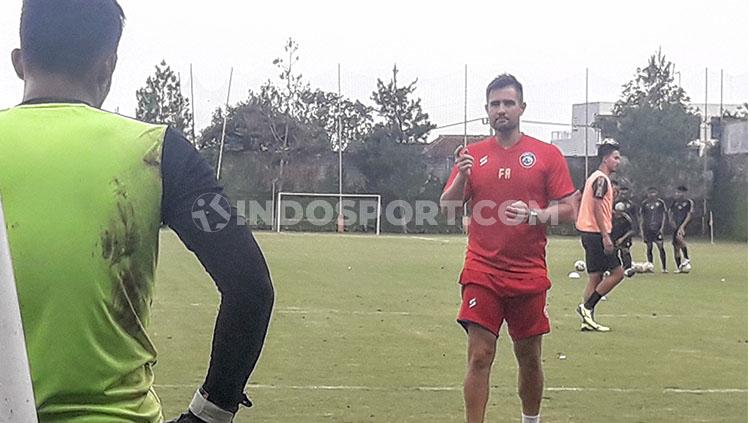 Kiper Arema FC, Teguh Amiruddin, mendengarkan instruksi dari Felipe Martins Americo. - INDOSPORT
