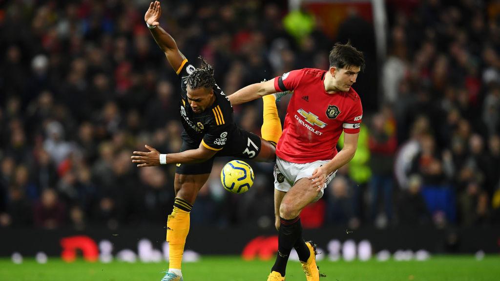 Adama Traoure berduel dengan Harry Maguire di laga Manchester United vs Wolves Copyright: Clive Mason/Getty Images