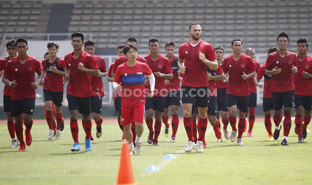 Para pemain Timnas Indonesia kompak berlari-lari kecil di lapangan Stadion Madya.