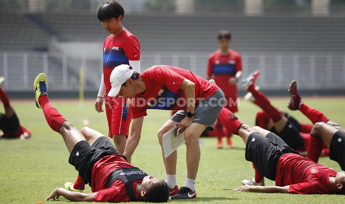 Shin Tae-yong membantu mengarahkan gerakan latihan kepada para pemain Timnas Indonesia.