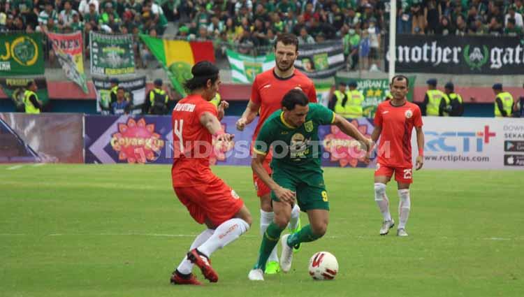 Pemain Persebaya Surabaya, Mahmod Eid (tengah) dihadang dua pemain Persija Jakarta pada babak final Piala Gubernur Jatim 2020 di Stadion Gelora Delta Sidoarjo, Kamis (20/02/20).