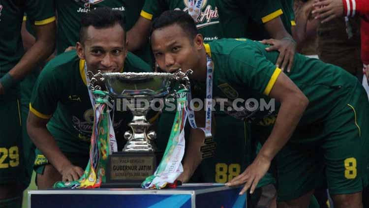 Dua pemain Persebaya, Irfan Jaya (kiri) dan Oktavianus Vernando mencium Piala Gubernur Jatim di Stadion Gelora Delta Sidoarjo, Kamis (20/02/20).