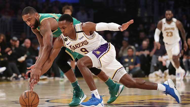 Perebutan bola terjadi antara bintang basket LA Lakers, Rajon Rondo (kanan) dengan penggawa Boston Celtics, Brad Wanamaker dalam pertandingan NBA musim reguler 2019-2020. Copyright: Katelyn Mulcahy/Getty Images