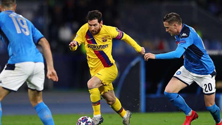 Bintang Barcelona, Lionel Messi, terpeleset karena tertipu oleh trik dari kiper Napoli, David Ospina dalam leg pertama babak 16 besar Liga Champions. - INDOSPORT